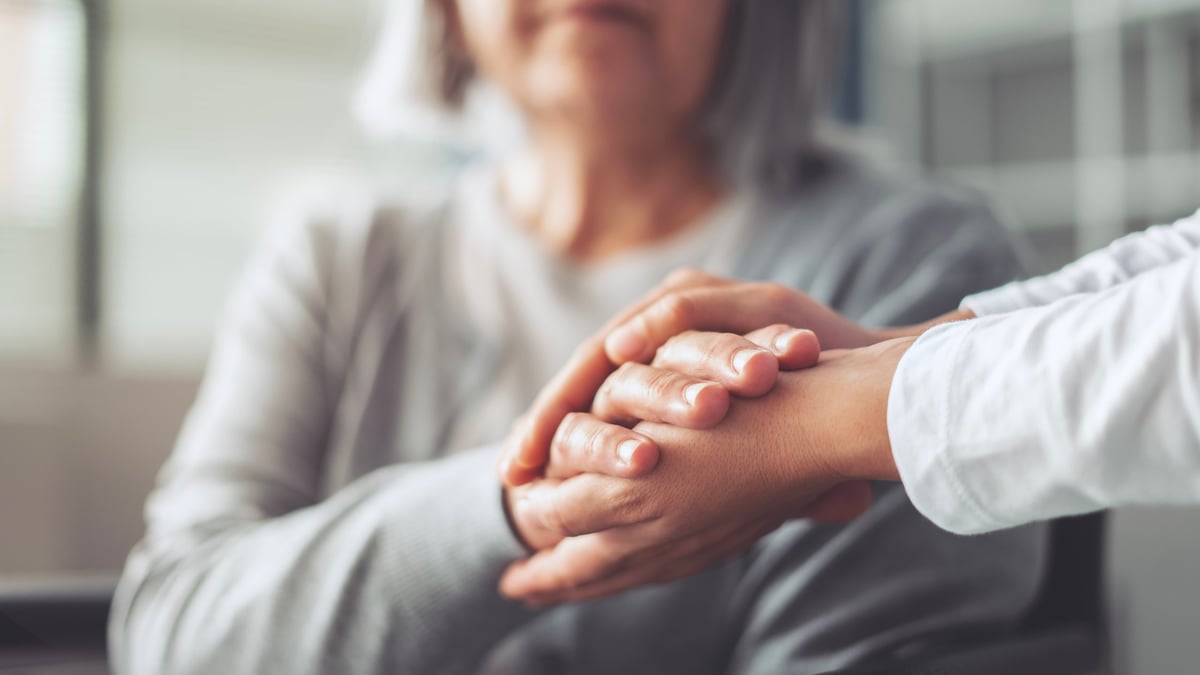 Hands holding old woman's hands