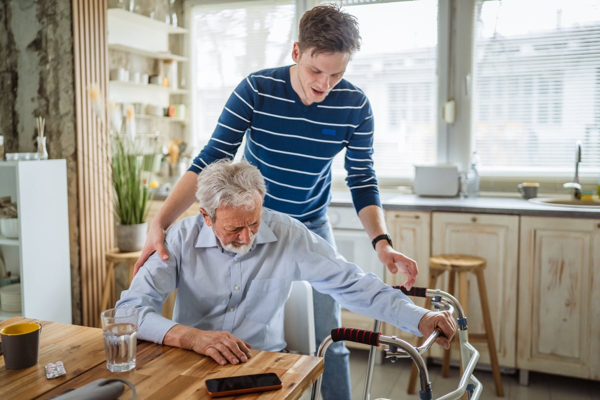 Caregiver assisting senior with walker